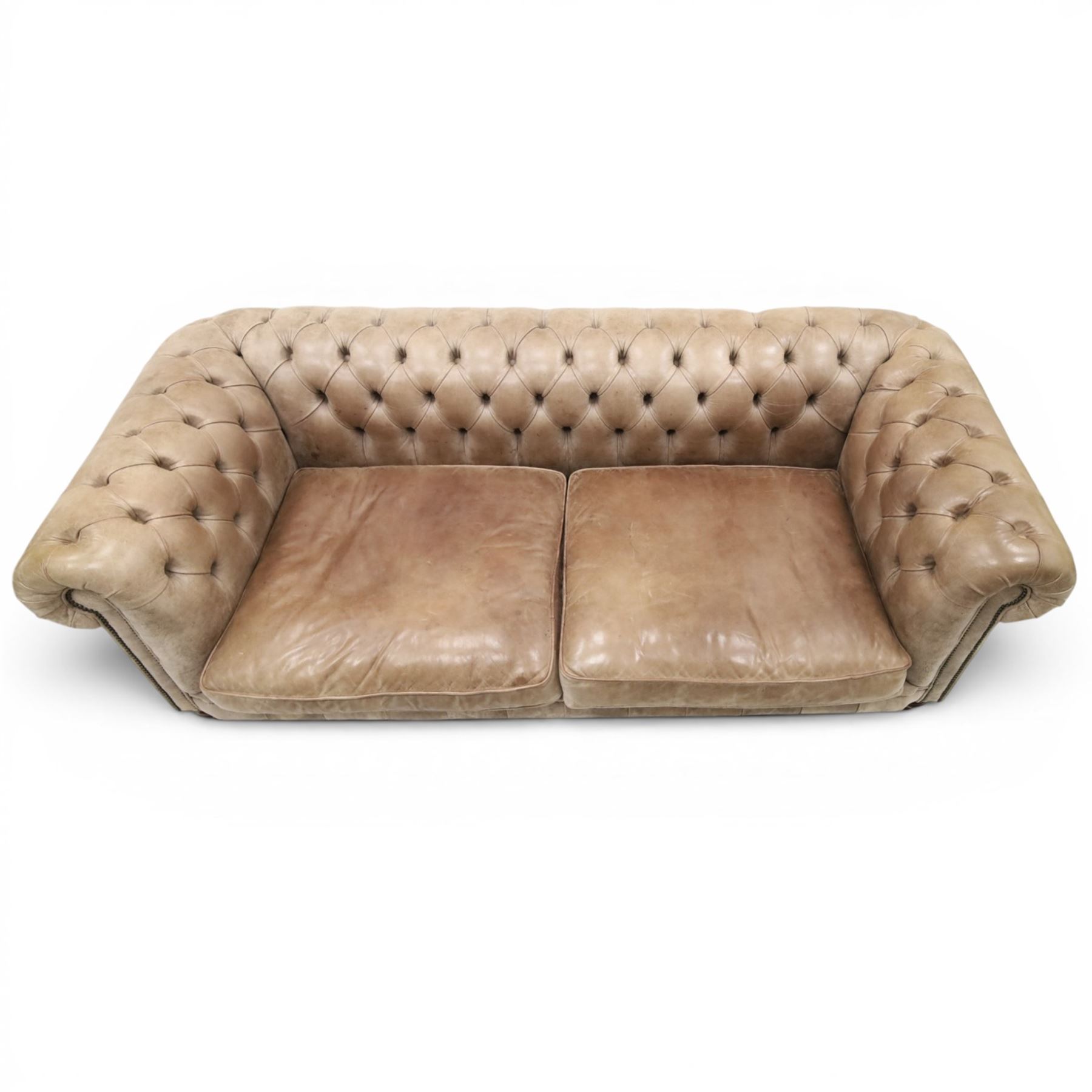 Distinctive Chesterfield - Chesterfield upholstered in taupe leather, deep button back and arms, loose seat cushions, raised on dark stained supports 