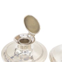 Two early 20th century silver mounted capstan inkwells, both of typical form, the first example hallmarked Wilmot Manufacturing Co, Birmingham 1918, the second example hallmarked Spooner Clowes & Co, Birmingham 1908, largest D15cm, H9.5cm
