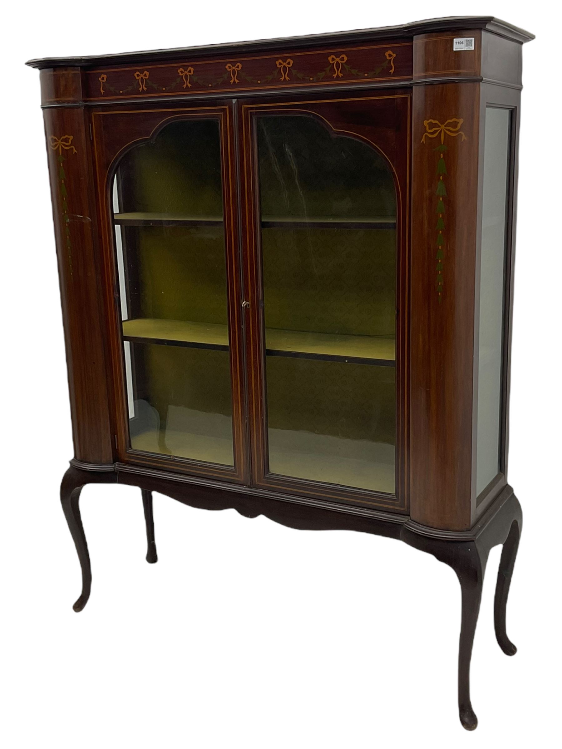 Edwardian mahogany display cabinet, shaped front with painted ribbon and bellflower garland decoration, enclosed by two glazed doors, cabriole supports