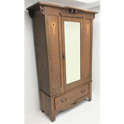 Arts and Crafts period oak wardrobe, projecting shaped cornice, single bevel edged mirrored door above drawer