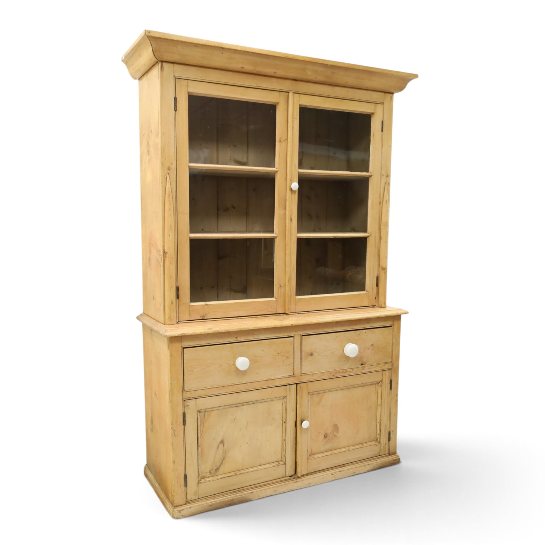 Victorian stripped pine and glazed dresser, projecting ovolo cornice over glazed doors enclosing two shelves, the base fitted with two drawers over panelled cupboards with ceramic handles, on moulded skirted base