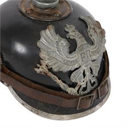 WWI Prussian M1915 Pickelhaube, the black leather skull with removable steel spike finial, steel eagle helmet plate and leather chin strap, one side with a black cockade, the other black and red
