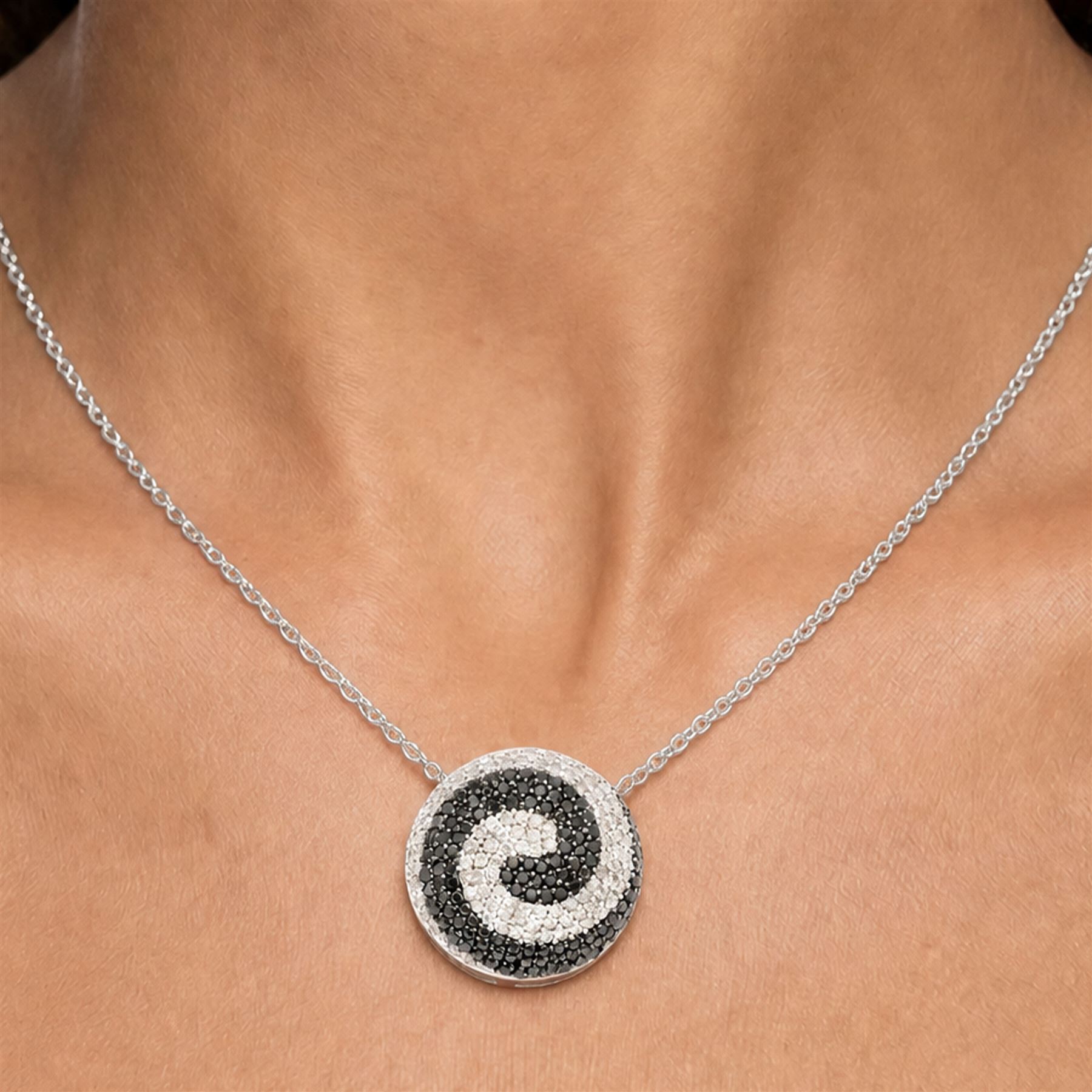 9ct white gold diamond swirl pendant necklace, circular pendant pave set with black and white diamonds, on a fine trace link chain necklace, both hallmarked, total diamond weight approx 1.55 carat