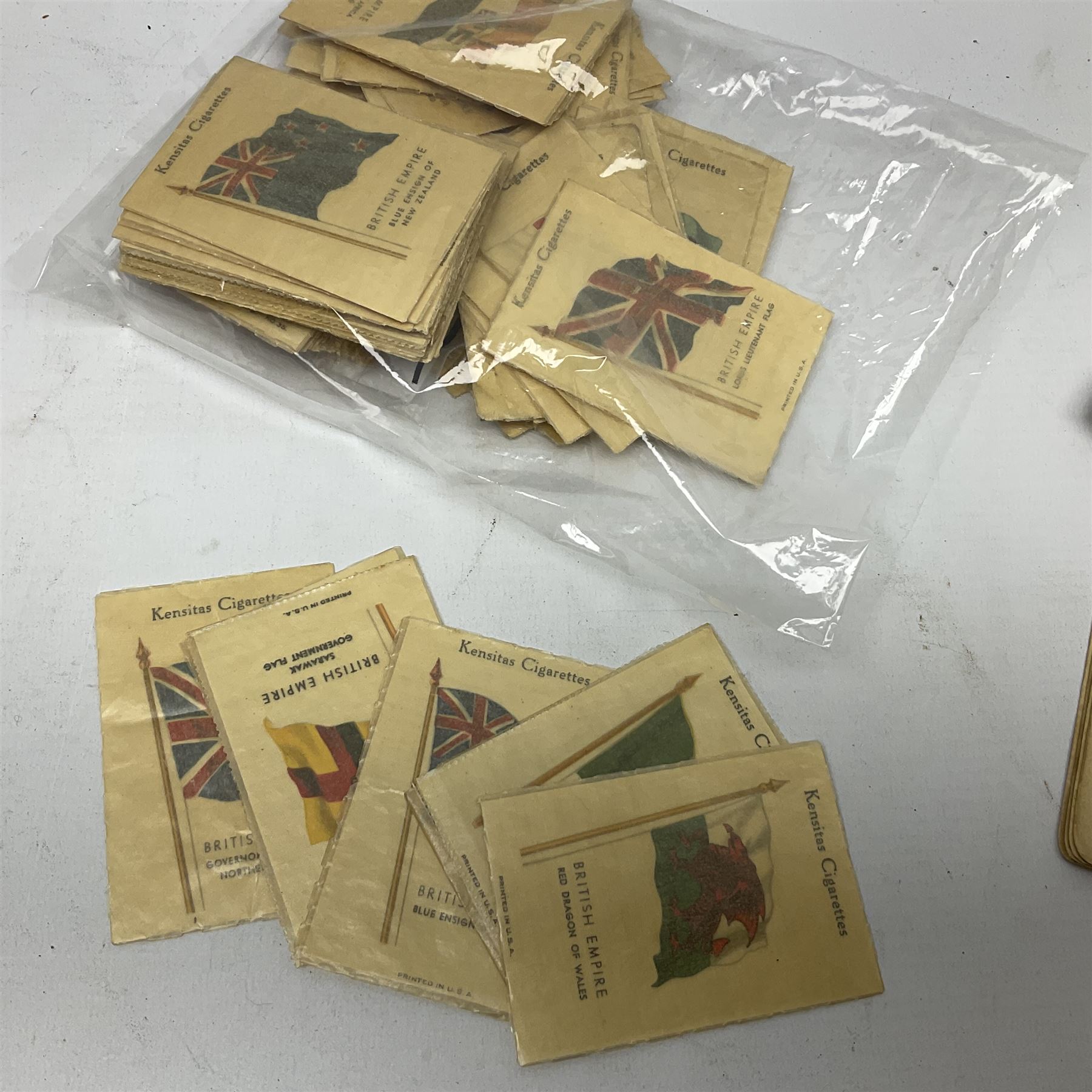 Quantity of Kensitas silk cigarette cards depicting world flags, together with albums of fish cigarette cards and quantity of crowns to include boxed examples