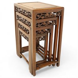 Early 20th century Chinese style hardwood quartetto nest of tables, each with panelled top and carved and pierced vine motif frieze, on square legs united by straight stretchers