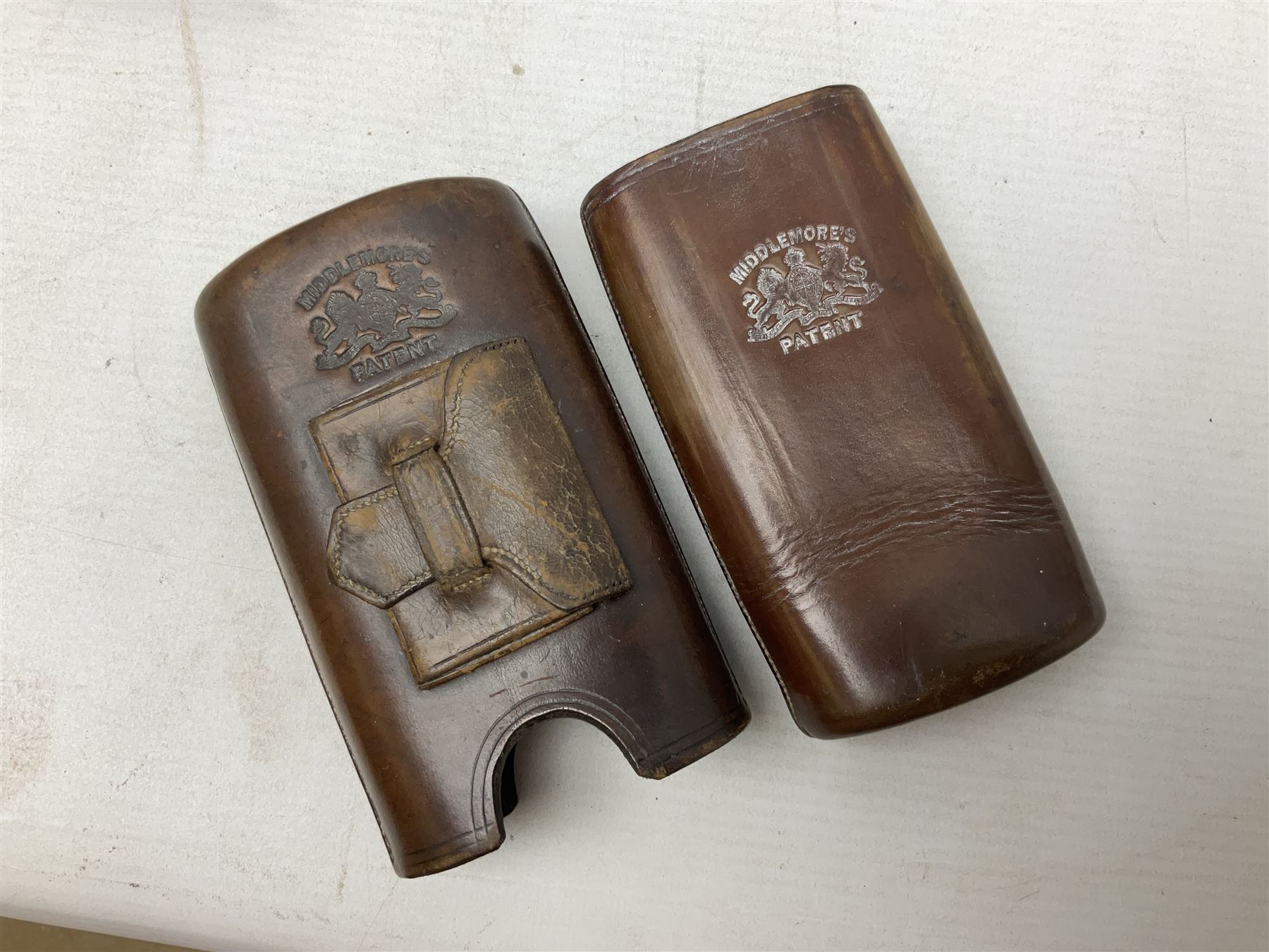 Victorian leather cigar protector with metal match striking plate on the end and internal spring to hold the cigars in place; expands for differing lengths of cigar, minimum L12.5cm; another similar leather cigar case marked Middlemore's Patent with attached vesta case and striker; three Bryant & Mays tin-late matchbox holders including 1935 Jubilee; and small box of matches (6)