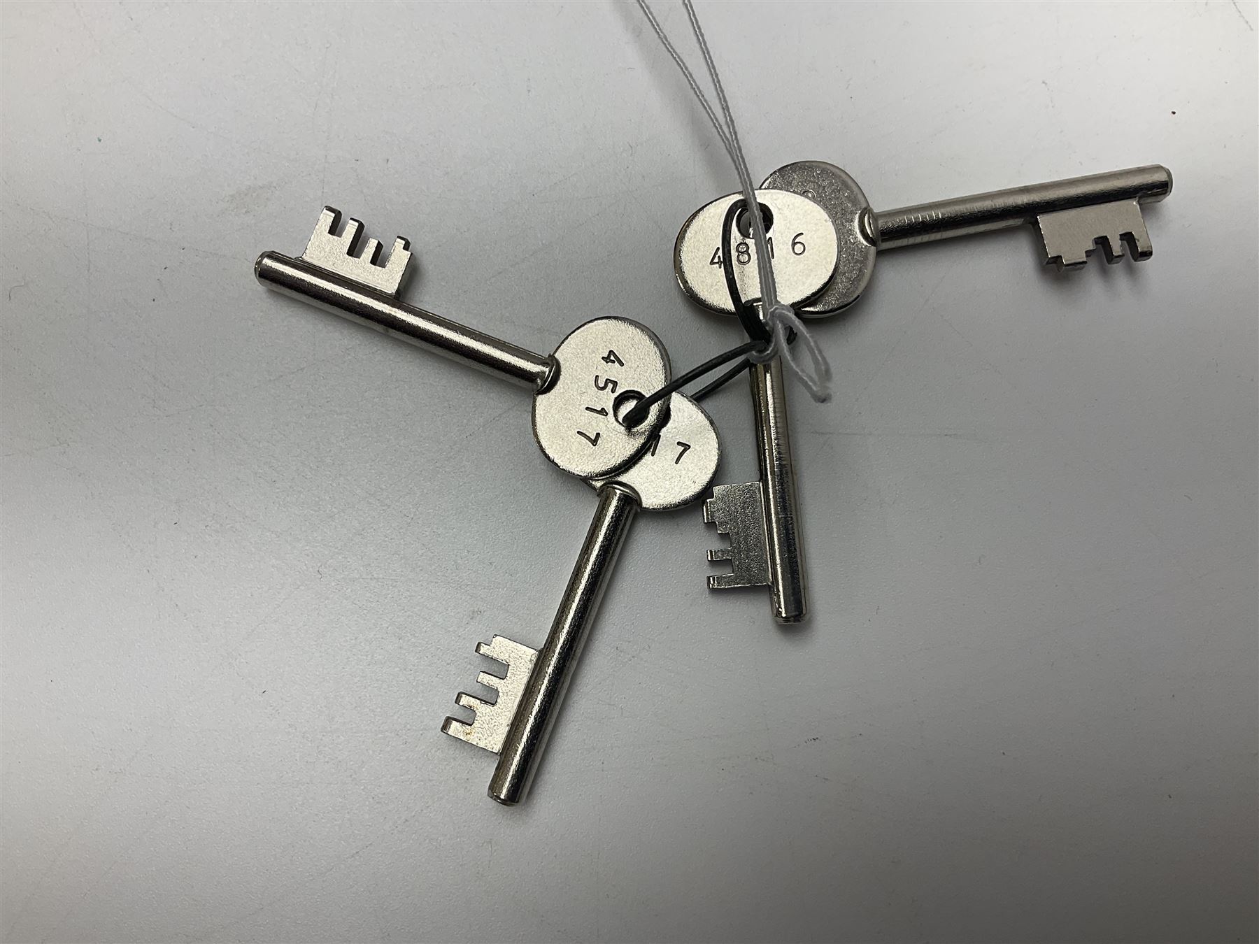 Two-tone grey steel wall-mounting gun cabinet by Sambell Engineering to accommodate six guns with fixed shelf over, gun space int. H132cm W36.5cm D23.5cm, the single double-locking door with two sets of keys, ext. H154cm W37cm D27cm