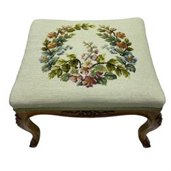 19th century French walnut dressing stool, rectangular seat upholstered in a floral needlework tapestry top, shaped apron with applied carved flower heads, on cabriole supports with acanthus carved feet