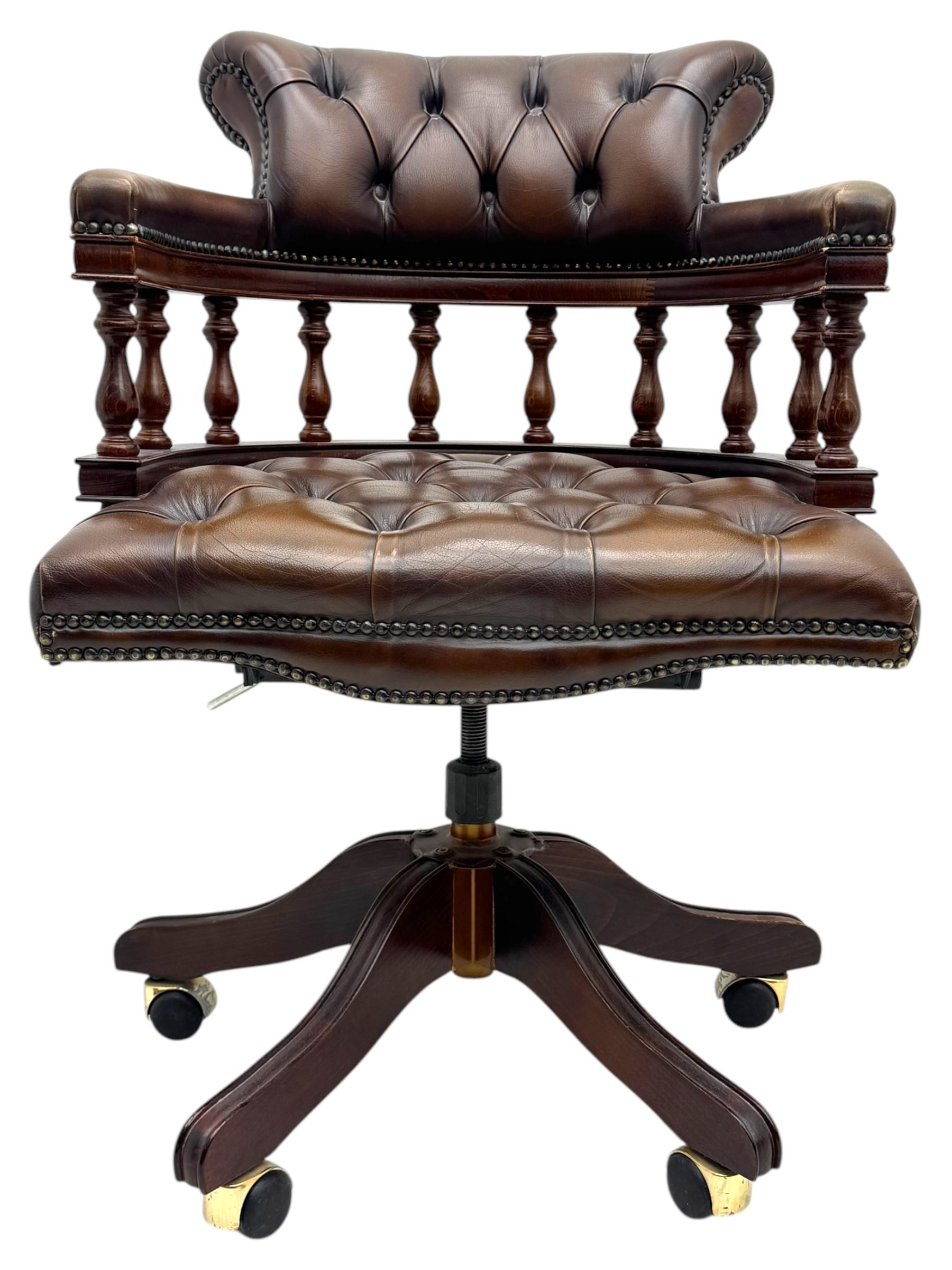Mahogany framed swivel Captains desk chair, upholstered in brown buttoned leather, turned supports and swivel base on castors