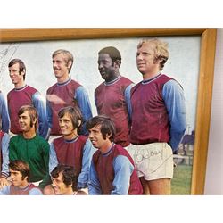 1970-1 photograph of West Ham United FC squad members, including Bobby Moore, Geoff Hurst, Harry Redknapp, Trevor Brooking, Jimmy Greaves, Billy Bonds etc, most players with signatures, 30 x 45cm, framed and glazed