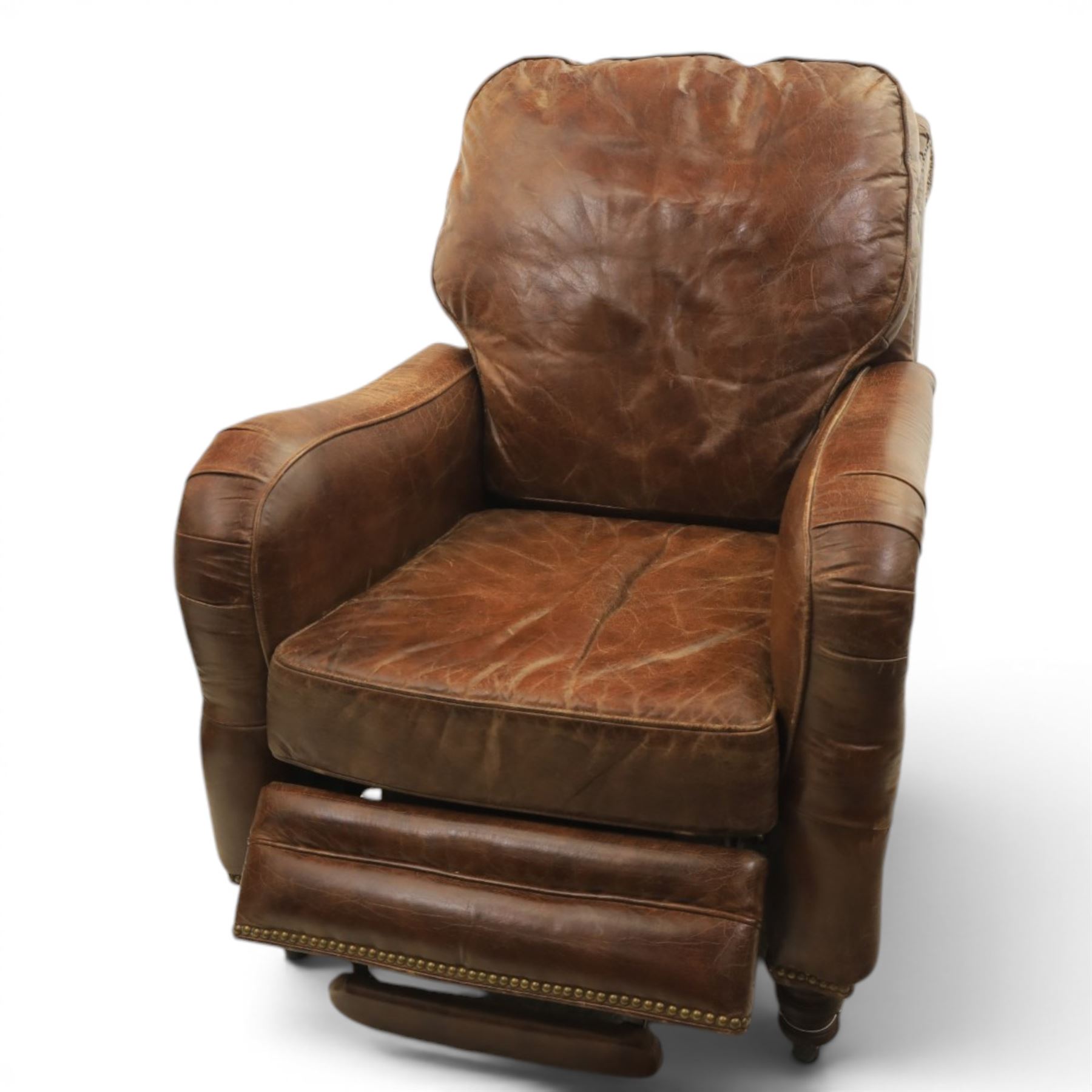 Art Deco style brown leather reclining armchair, scrolled arms with brass studded trim, reclining foot rest and back, fixed back and loose seat cushion,