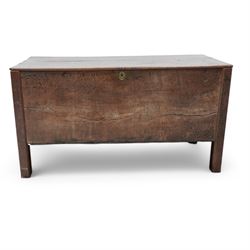 Large late 17th Century oak coffer, the hinged lid with twin rear strap hinges above a plain front with inset brass escutcheon, raised on square supports with pegged joinery and displaying pronounced grain figuring to the single front board