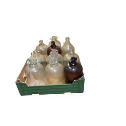 Eleven glass demijohns, including two brown glass examples