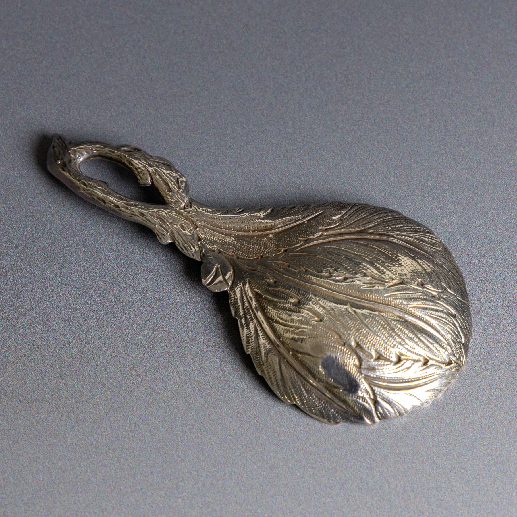 Late 20th century silver caddy spoon, naturalistically modelled with leaf shaped bowl, flowers and buds to centre, hallmarked Sheffield 1993, maker's mark indistinct