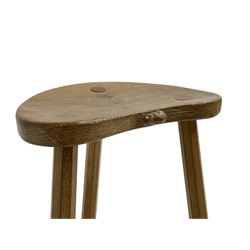 Mouseman - oak three legged milking stool, dished kidney-shaped top on three splayed supports, carved with mouse signature, by the workshop of Robert Thompson, Kilburn