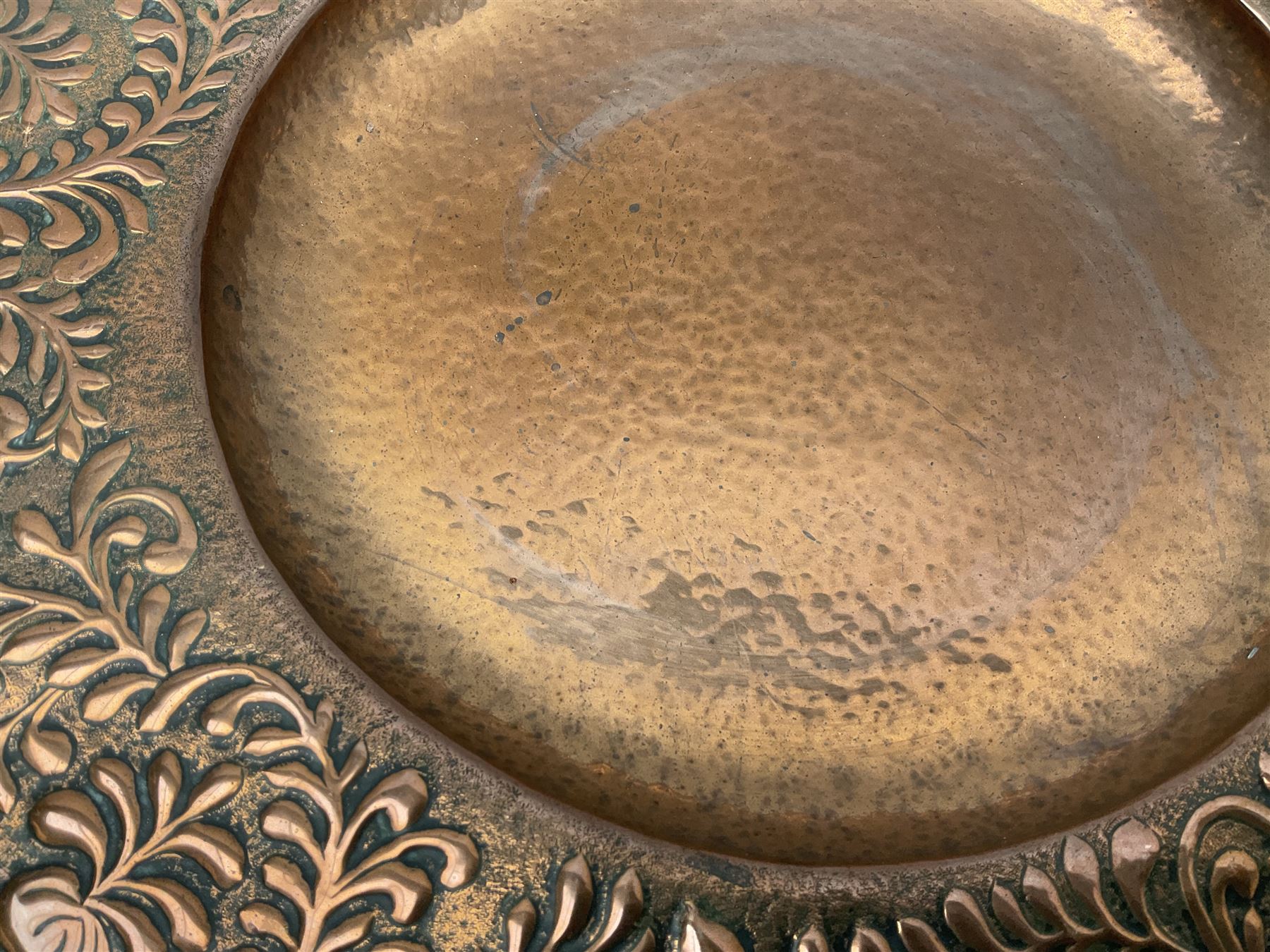 Arts and Crafts Keswick School of Industrial Arts copper charger, decorated with planished centre and repousse scrolling foliate tendrils to rim, D44cm