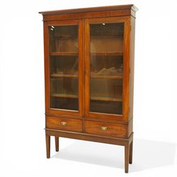 19th century mahogany enclosed bookcase on stand, projecting cornice and banded frieze over two glazed doors enclosing four adjustable shelves, fitted with two drawers to base, on square tapering supports
