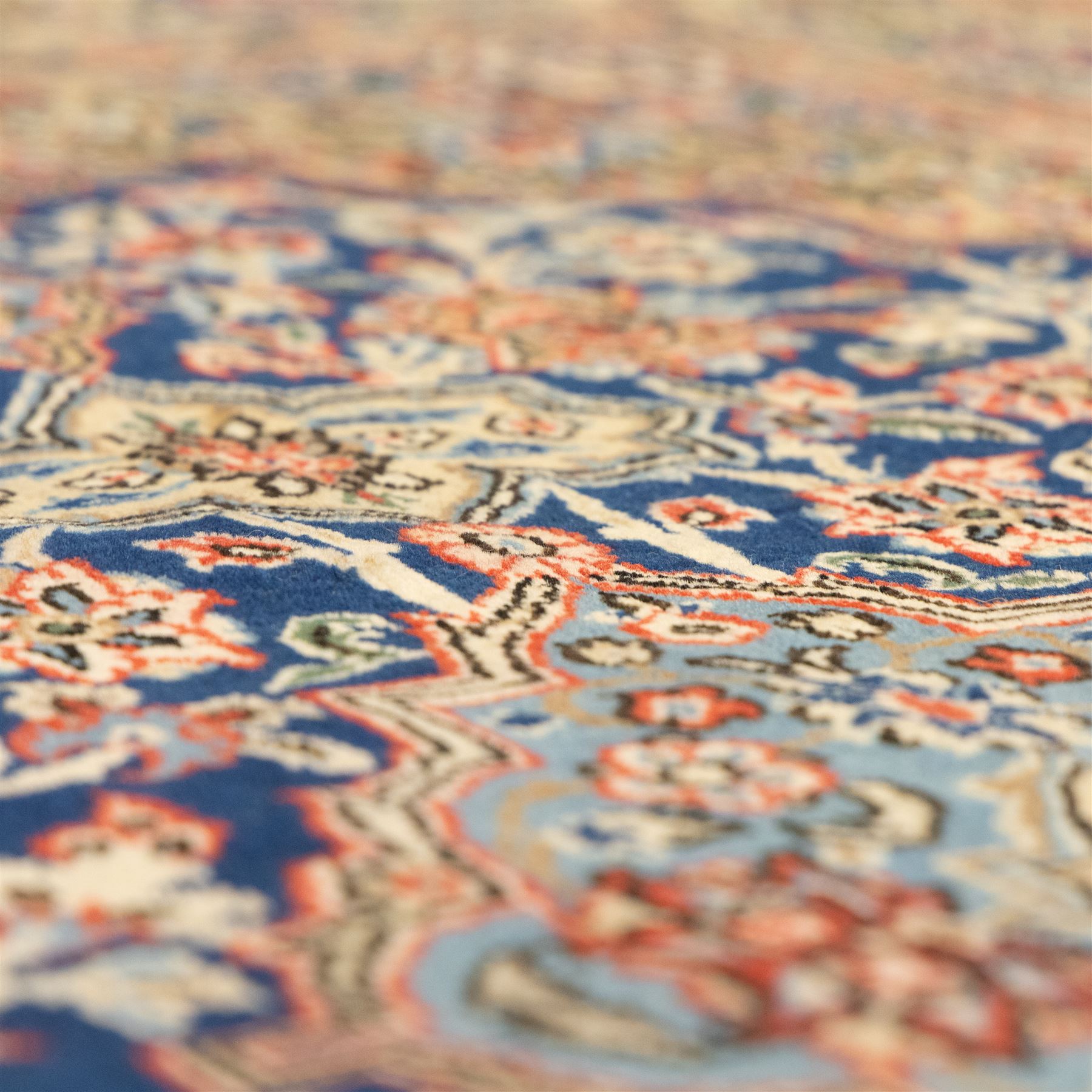 Persian Kashan rug, navy field with lobed central medallion and scrolling floral sprays, ivory spandrels within a palmette and vine border