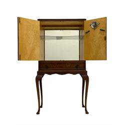 Mid-20th century walnut cocktail cabinet, two figured doors enclosing mirrored interior, fitted with single drawer, on acanthus carved cabriole supports