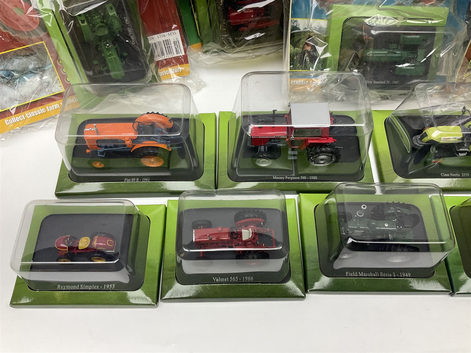 Eighteen issues of Tractors and The World of Farming magazine, together with sixty diecast tractors, all in original packaging, in three boxes 