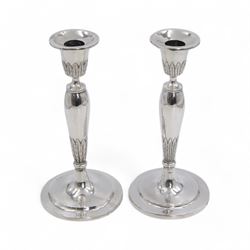 Pair of continental silver candlesticks, probably German Hanau, each of tapering form, with fern leaf decoration, upon a stepped circular base, with Hanau marks and assay scrape to base, H19cm