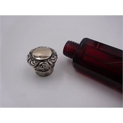 Victorian double ended ruby glass scent bottle, the faceted body with silver foliate detailed hinged cover to one end, and conforming silver screw threaded cover to the other, L13cm, unmarked but testing as silver