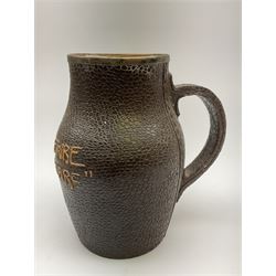 A Doulton Lambeth stoneware jug, with silver mounted collar, hallmarks rubbed, maker's mark probably Cornelius Desormeaux Saunders & James Francis Hollings (Frank) Shepherd, the leather effect body titled 'Drinke Faire Don't Sware', with impressed marks beneath including 'Manufactured for Sidney W Allen 39 White Rock Hastings', H18.5cm. 