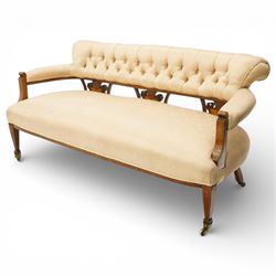 Edwardian inlaid mahogany sofa, upholstered in cream fabric with buttoned back rail, tapering legs on brass castors