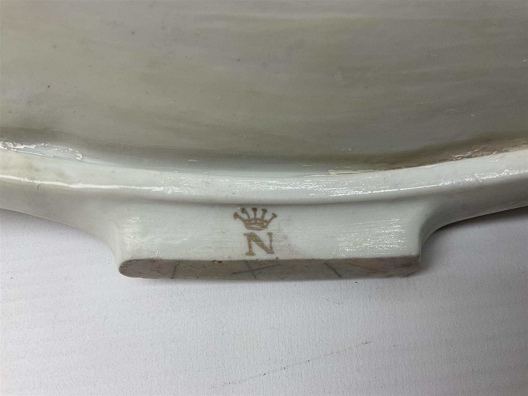 20th century Naples figure group, modelled as a seated female figure playing the lute seated, before a male figure stood holding a sheet of music, each in period dress, upon an oval base with gilt heightened scroll edge, with crowned N mark beneath, H31.5cm L33cm
