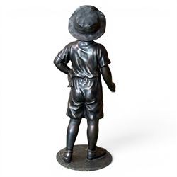 Bronzed composite figure of a boy wearing a hat, on circular plinth