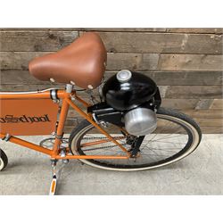 Fully restored vintage advertising bicycle with 2 stroke petrol engine, orange frame, tan leather seat