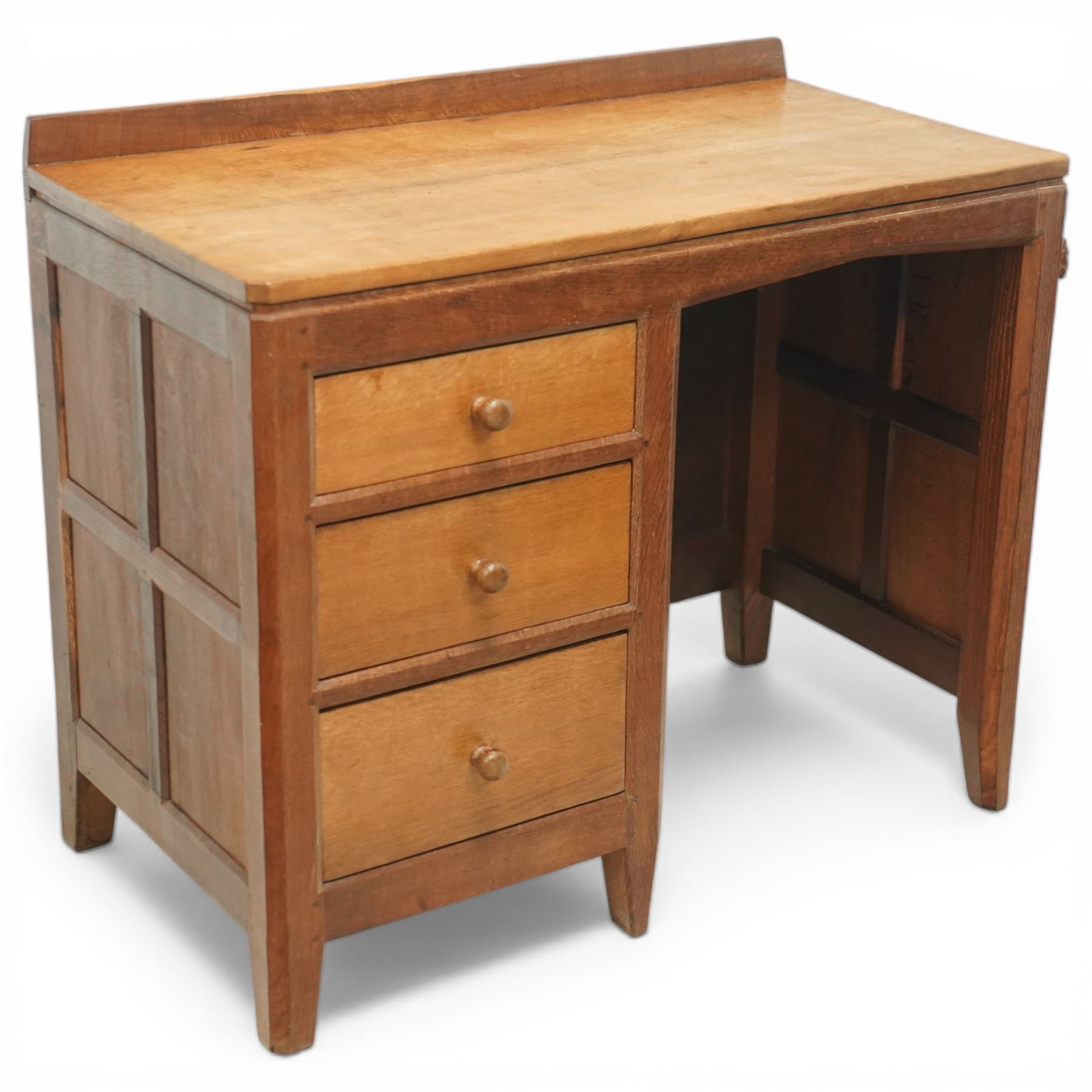 Rabbitman - oak single pedestal desk, adzed top with galleried back, with three graduating drawers with turned wooden knobs, enclosed kneehole with adzed detailing throughout the panelling and supports, with carved rabbit signature, by Peter Heap of Wetwang