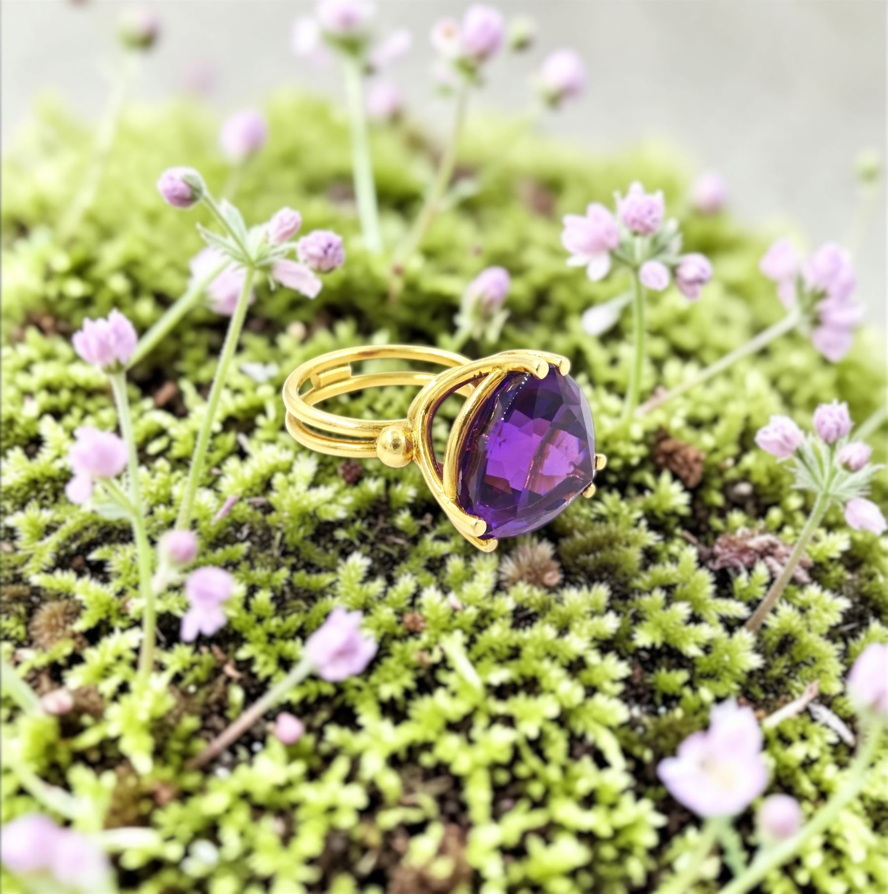 18ct gold amethyst ring, set with a single trilliant cut amethyst of approx 11.50 carat, to a fancy split design shank
