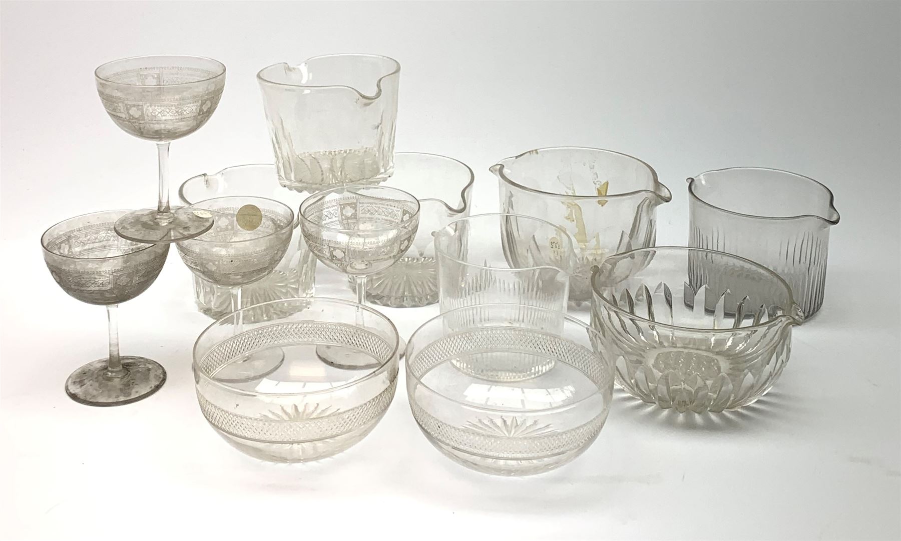 Seven 19th century and later double lip glass rinsers of various design, together with a pair of Edwardian cut glass finger bowls, and four Edwardian champagne glasses with engraved decoration. 