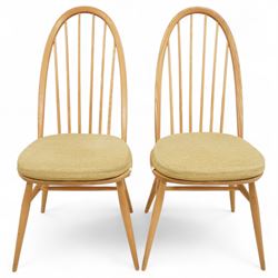 Ercol - light elm set of four Quaker style chairs, high arched backrest with slender spindles, solid wood seat with elasticated strap cushion, on round tapered out swept legs (4)