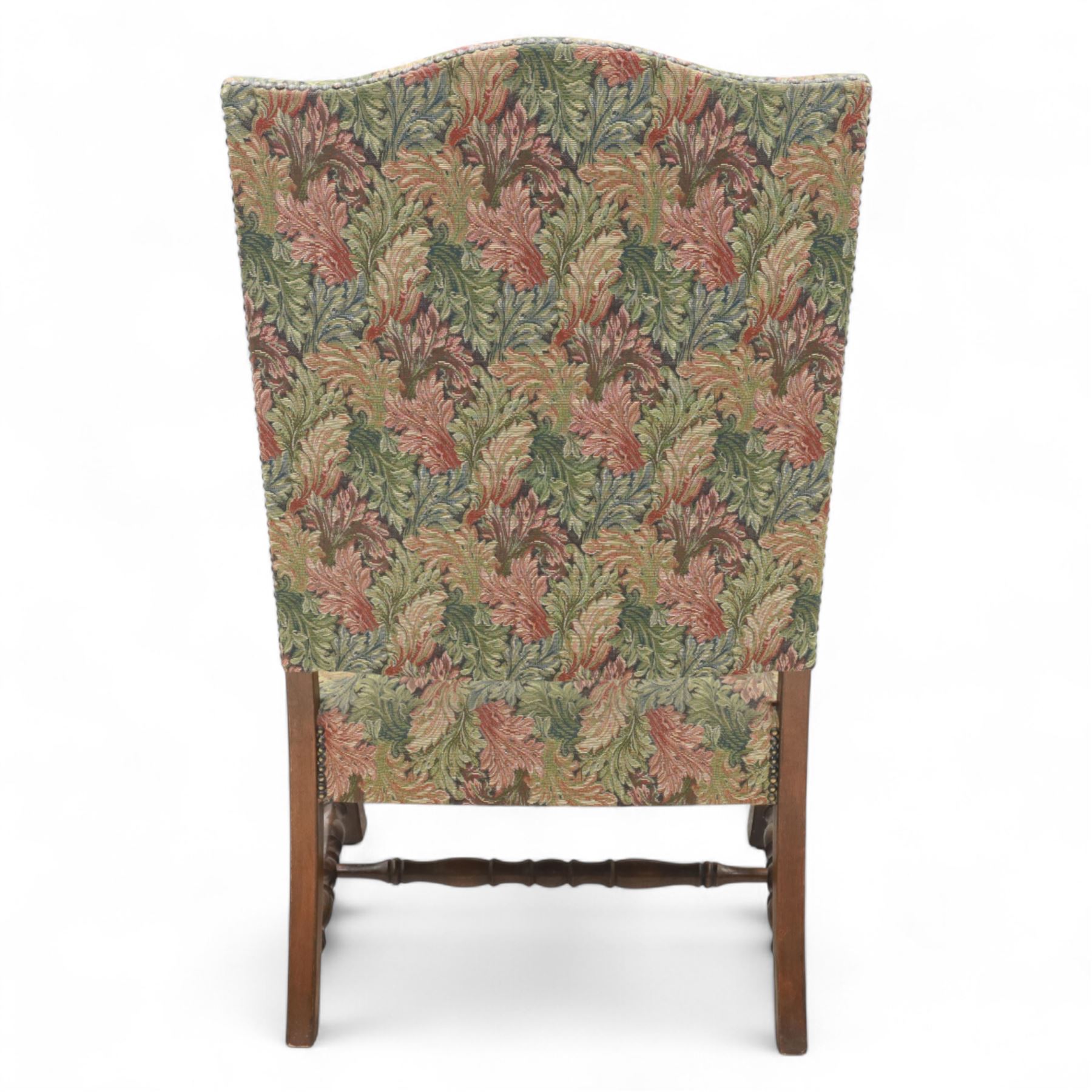 Early 20th-century Jacobean revival open oak armchair, arched padded back, and seat button upholstered  in foliate tapestry style fabric, with scroll carved arms on turned supports, raised on block supports united by turned shaped stretchers 