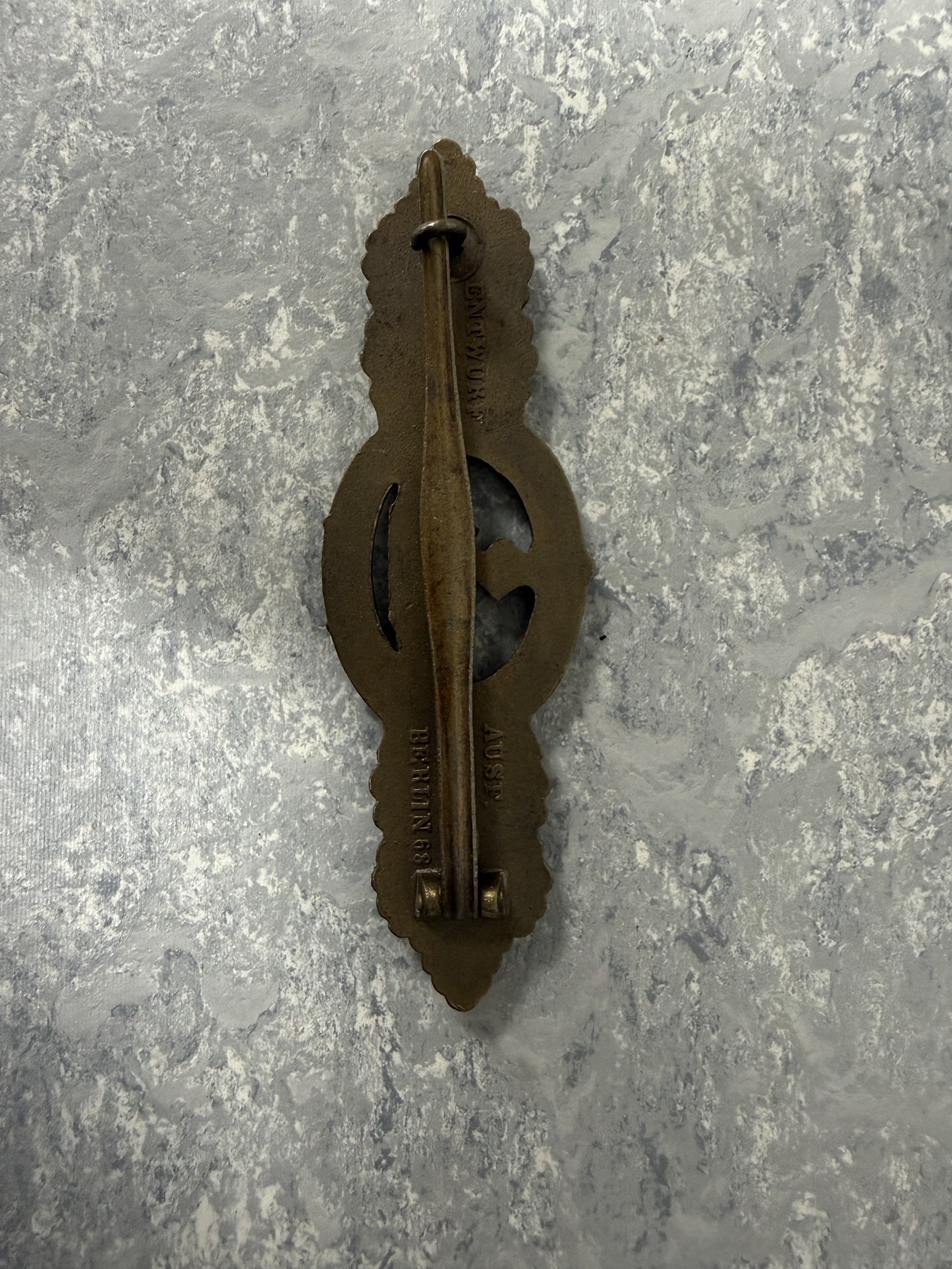WWII German Kriegsmarine U-Boat combat clasp in bronze by Schwerin Berlin, with the original horizontal pin and catch fixing, makers mark to the reverse “ENTWURF PEEKHAUS AUSF SCHWERIN BERLIN 68” in original packaging