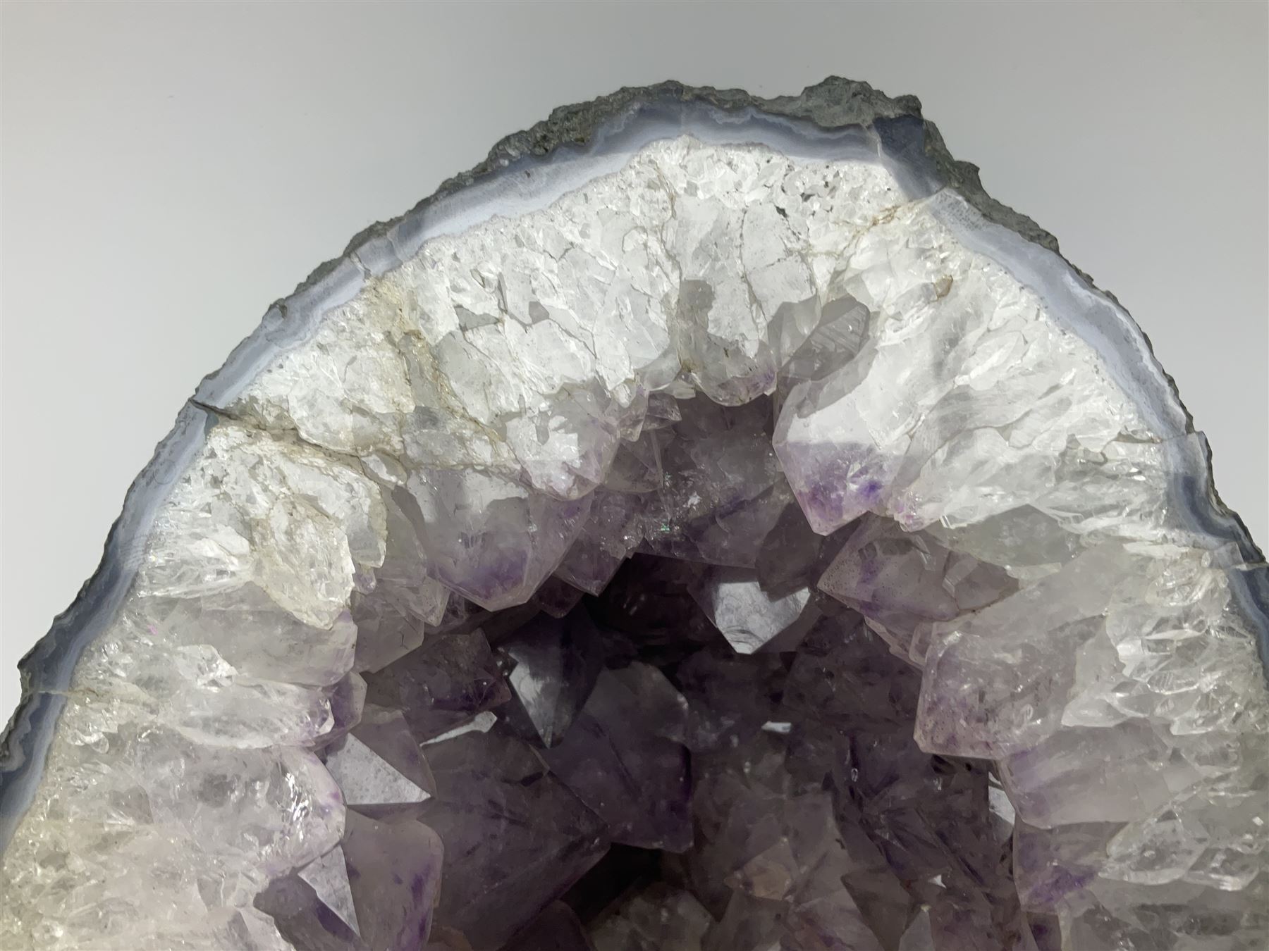 Amethyst crystal ‘cathedral’ geode, free standing with flat base and prepared outer surface, with well-defined crystals of various sizes within the cavern, H39, L32cm