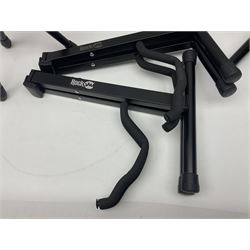 Four folding tubular guitar stands, two by RockJam; and folding tubular saxophone stand (5)
