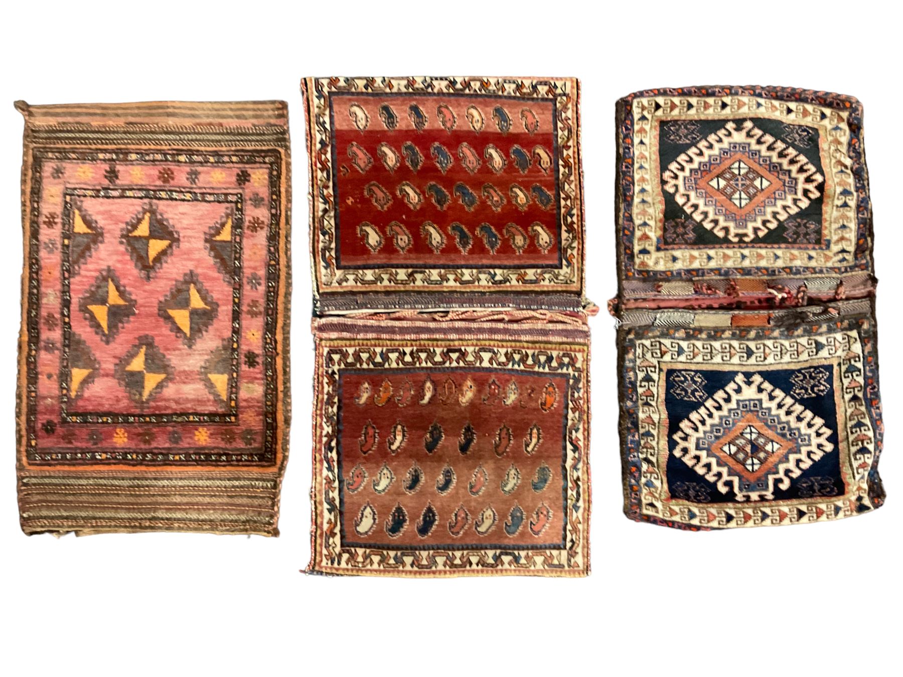 Antique Persian red ground saddle bag, decorated with all-over Boteh motifs, geometric patterned border (127cm x 68cm); Persian indigo ground saddle bag, decorated with two geometric ivory lozenges (113cm x 62cm); Persian red ground saddle bag decorated with lozenges and multi-band border (110cm x 65cm) 
