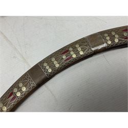 Late 19th/early 20th century Moroccan nimcha dagger-sword, the 40cm curving steel blade with engraved decoration on both sides; shaped hardwood hilt inlaid with brass, white metal wires and red coloured panels; in similarly inlaid scabbard L61cm overall