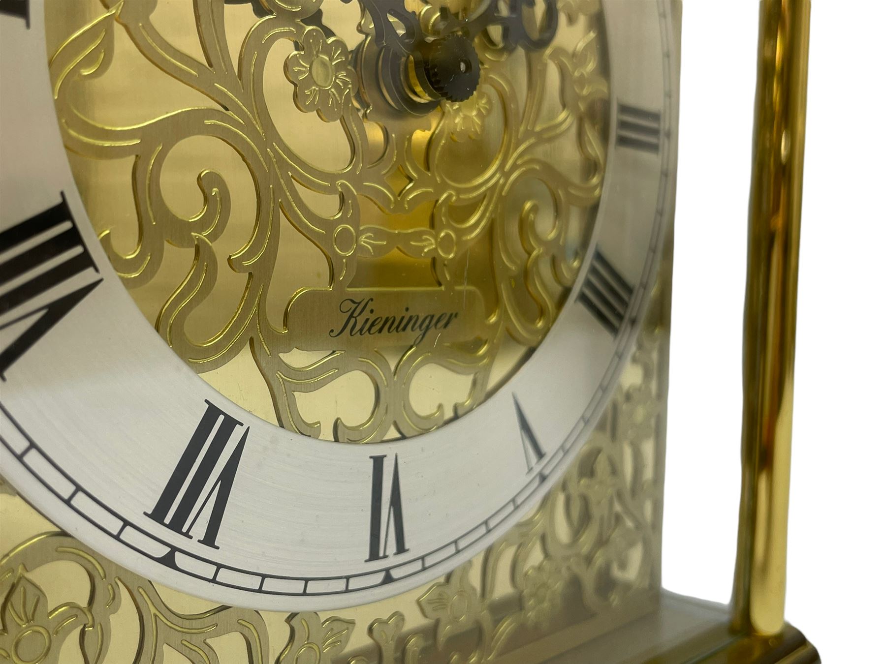 A 20th century brass cased Kieninger (German) chiming mantle clock with a break arch top and three glazed panels, polished sheet brass dial with applied  brass fretwork and a silvered chapter ring, Roman numerals, minute track, steel serpentine hands and seconds dial, three-train spring driven 8-day movement with Westminster, St Michael and Whittington chimes on 8 gong rods, 9 jewel lever platform escapement.  With key. 