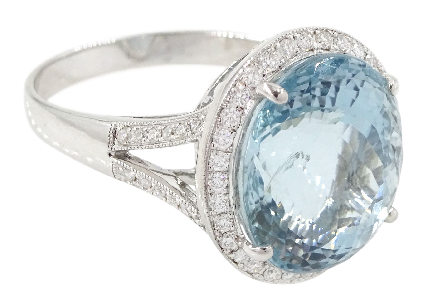 18ct white gold aquamarine and diamond cluster ring, single oval cut aquamarine of approx 8.20 carat, surrounded by milgrain set round brilliant cut diamonds, with diamond gallery and split diamond set shoulders, stamped 750, total diamond weight approx 0.30 carat