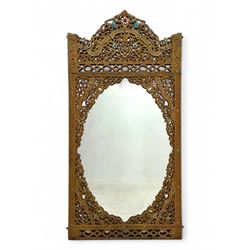 Large North African design carved and painted wall mirror, decorated with floral motifs, pierced foliate scrolls, inset mirrored panels, and colourful painted detailing, enclosing an oval bevelled mirror plate