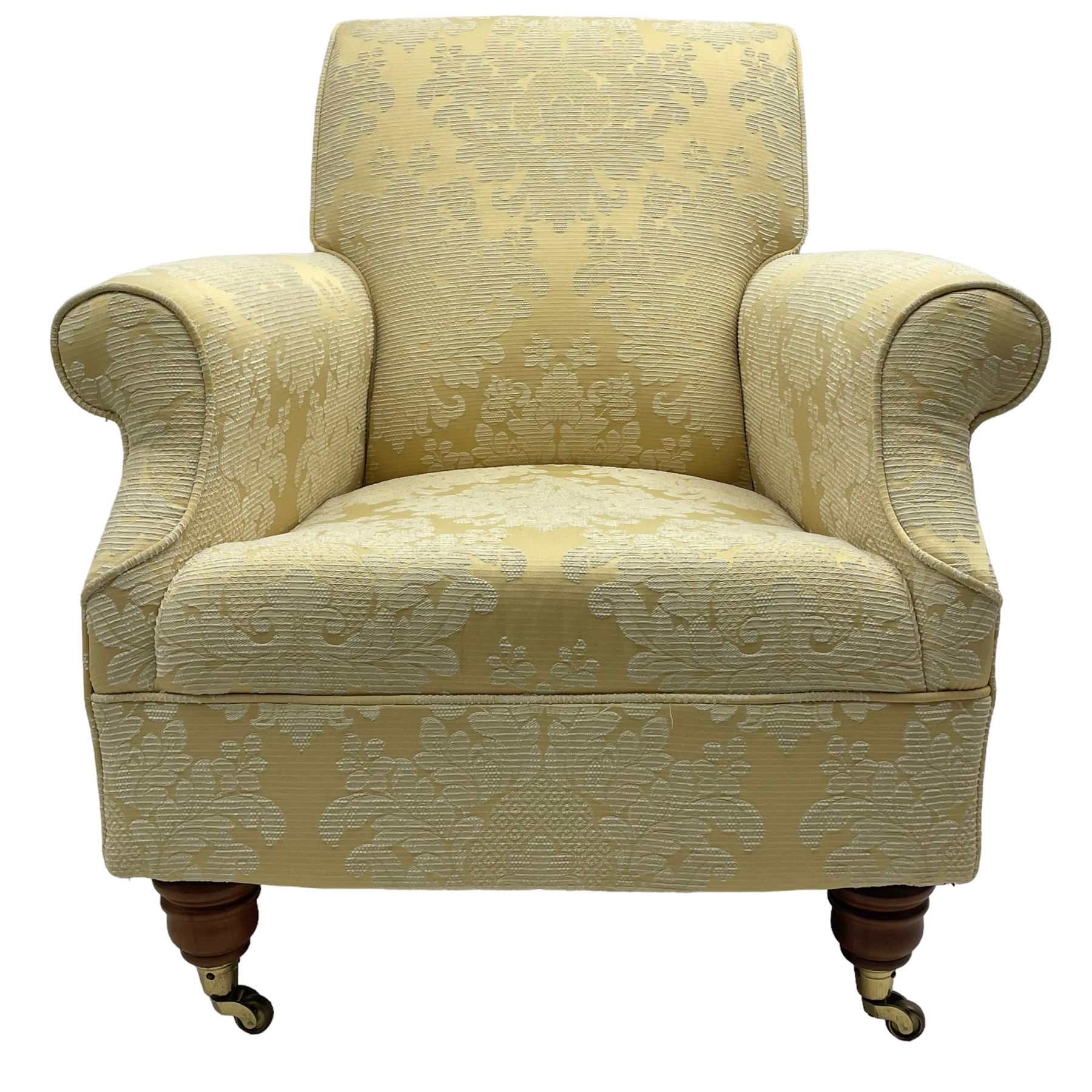 Traditionally shaped hardwood-framed armchair, rolled back and arms, upholstered in pale gold and cream damask fabric with repeating foliate pattern, on turned feet with brass cups and castors