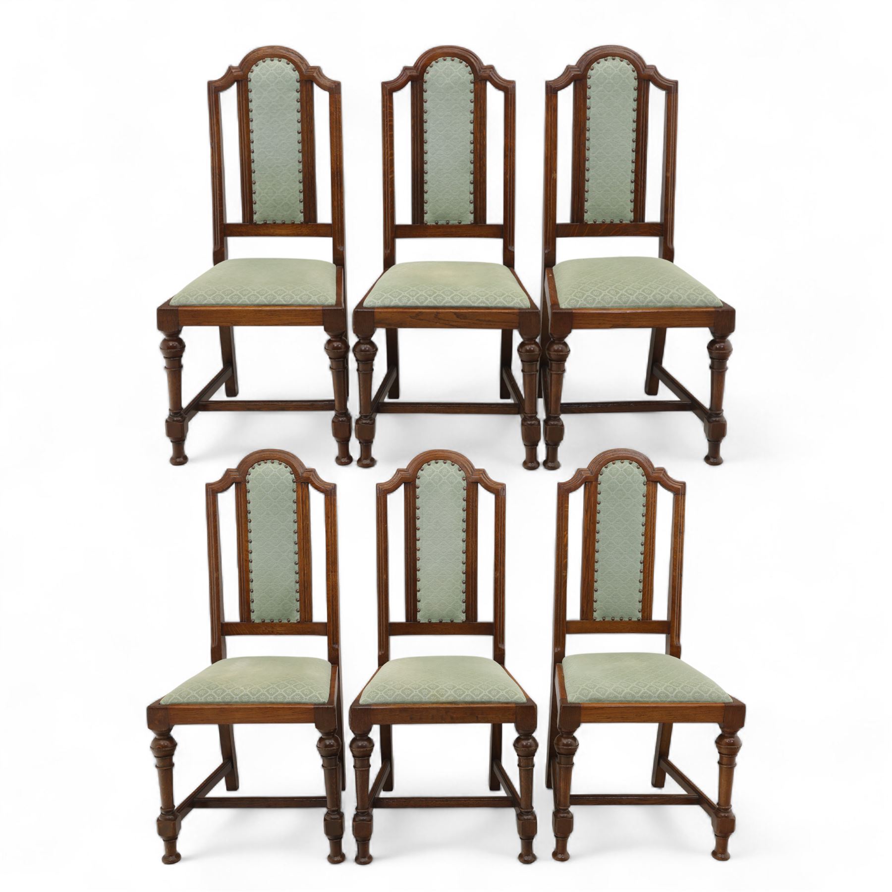 Victorian mahogany extending dining table, rectangular top with chamfered corners above a plain frieze raised on turned reeded legs with castors and two additional leaves, 197cm fully extended, and a set of six early 20th century oak upholstered chairs with drop-in seats, arched panelled back splat and close studded border on turned front legs joined by stretchers, 47x41x109cm 