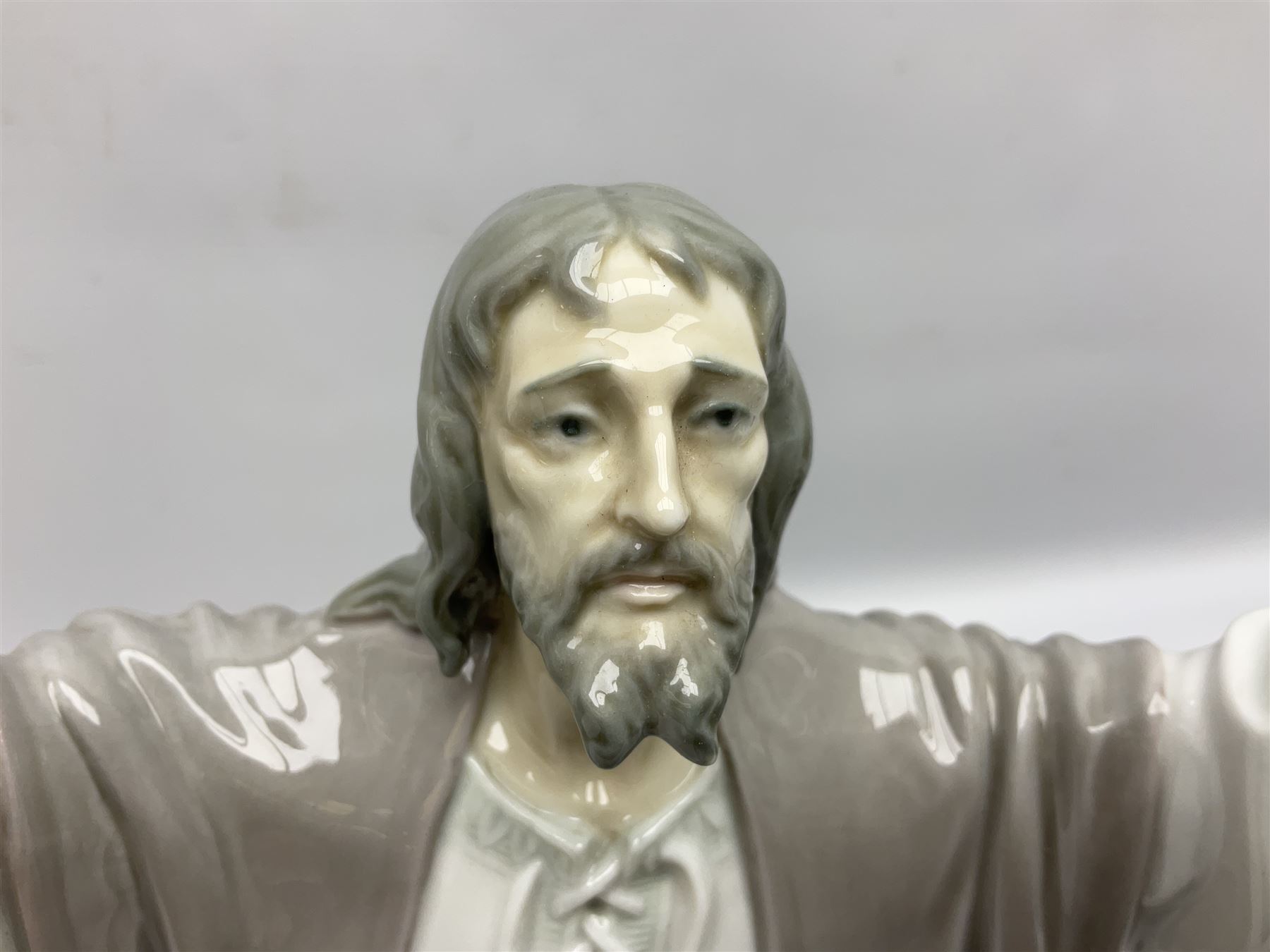 Lladro figure, The Loaves and Fishes, modelled as Jesus Christ with arms raised standing beside a basket of loaves and a basket of fish, sculpted by Salvador Furió, with original box, no 5896, year issued 1992, year retired 1997, H35cm