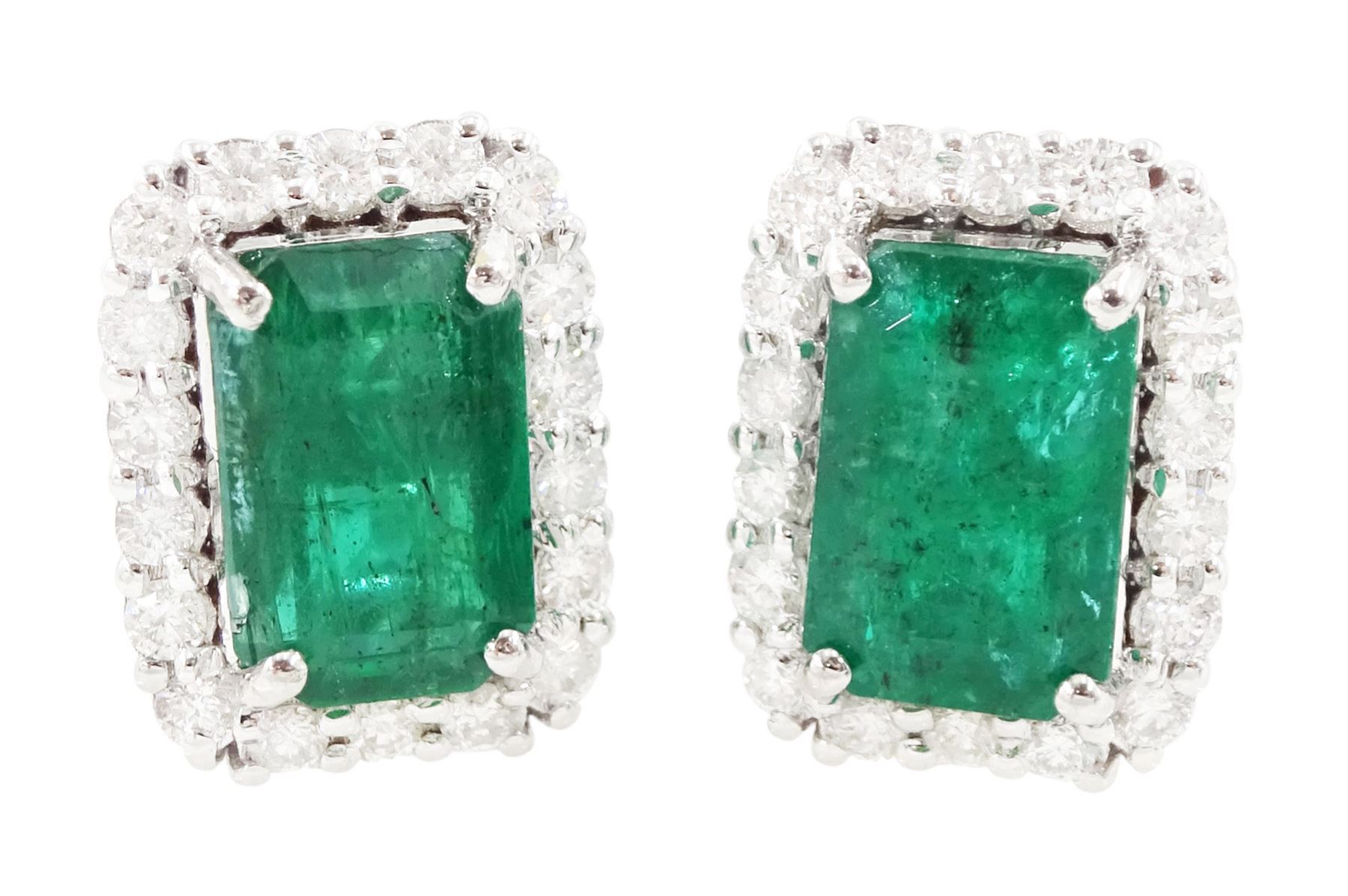 Pair of 18ct white gold emerald and diamond cluster earrings, each stud set with a single octagonal cut emerald, with round brilliant cut diamond surround, stamped, total emerald weight approx 3.00 carat