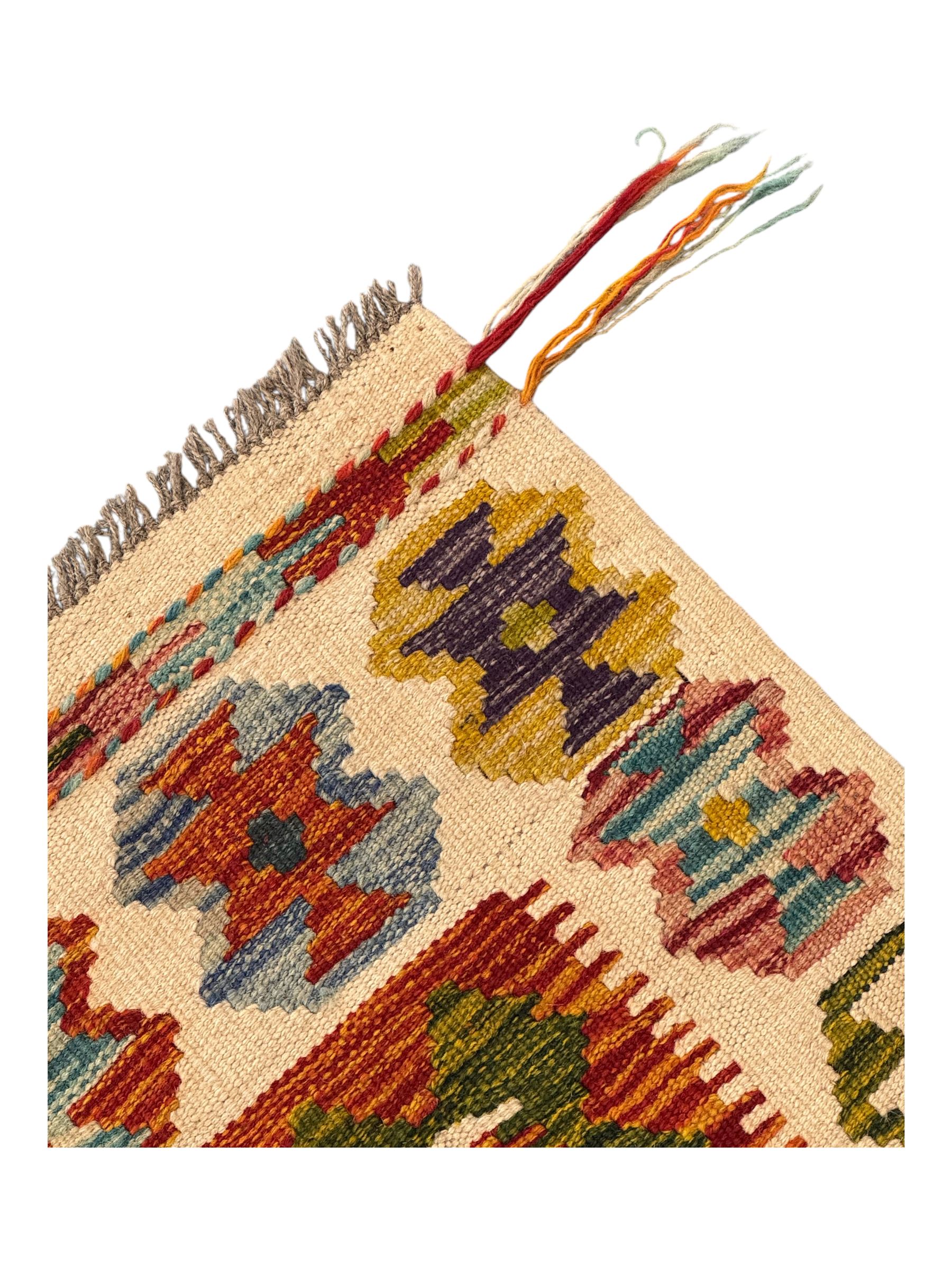 Chobi Kilim flatweave rug, cream ground with a multicoloured geometric diamond field, framed by a bold border of repeating stylised motifs, finished with braided corner tassels