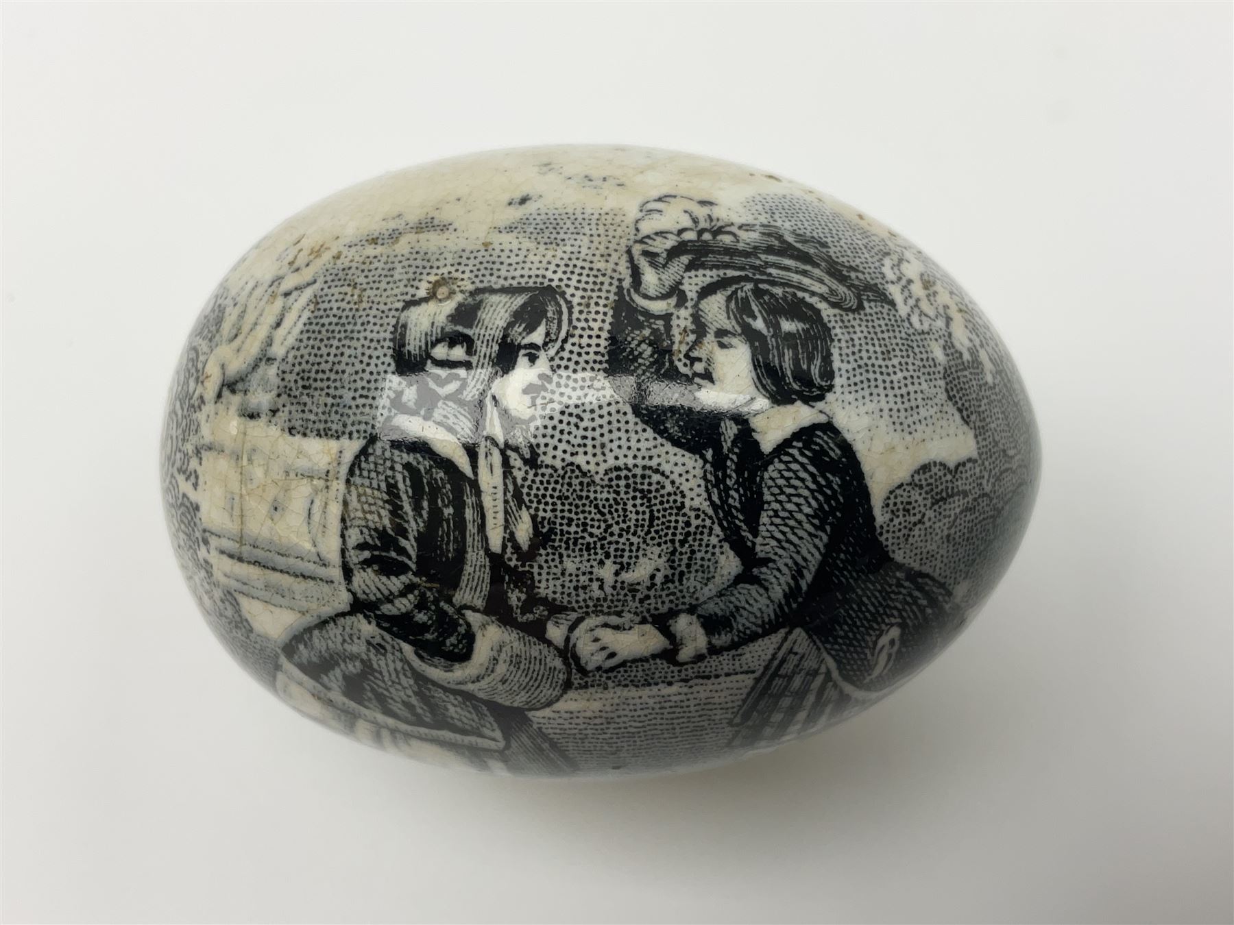 Victorian pottery egg transfer, printed with scenes 'Androcles and the lion' and a courting couple, L7cm 